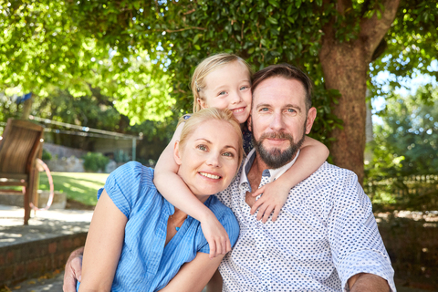 Porträt einer glücklichen Familie im Garten, lizenzfreies Stockfoto