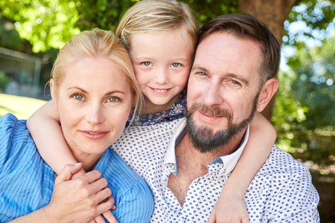 Porträt einer glücklichen Familie im Garten, lizenzfreies Stockfoto