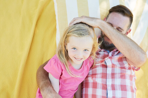 Glückliches Mädchen mit Vater auf einer Decke liegend - SRYF00647