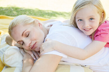 Mother and daughter relaxing lying on a blanket - SRYF00654