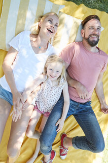 Glückliche Familie auf einer Decke liegend - SRYF00659