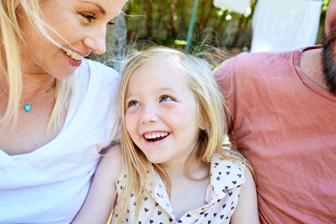 Portrait of happy girl between her parents stock photo