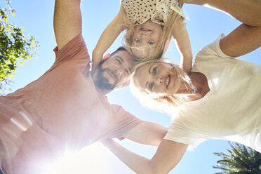 Porträt einer glücklichen Familie, die unter blauem Himmel kauert - SRYF00668