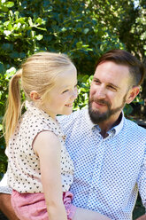 Smiling girl sitting on father's lap - SRYF00677