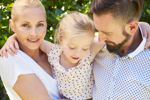 Portrait of happy girl between her parents stock photo