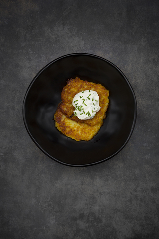 Potato fritters with herbed curd cheese in bowl stock photo