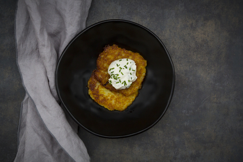 Potato fritters with herbed curd cheese in bowl stock photo