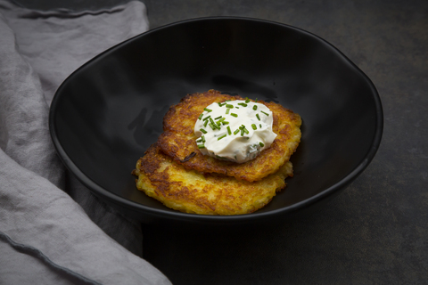 Kartoffelkrapfen mit Kräuterquark in Schale, lizenzfreies Stockfoto