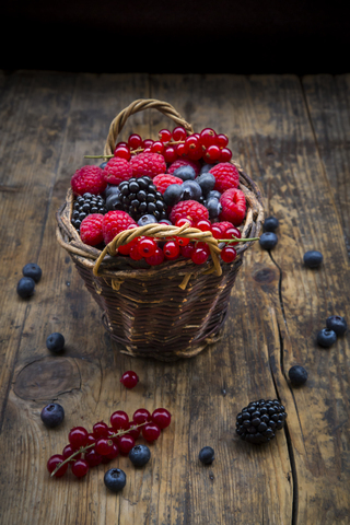 Wickerbasket of various berries on wood stock photo