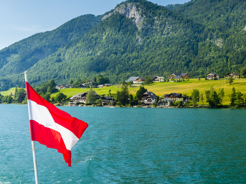 Austria, Salzkammergut, Salzburg State, Lake Wolfgangsee, St. Wolfgang, holiday homes and Austrian flag stock photo