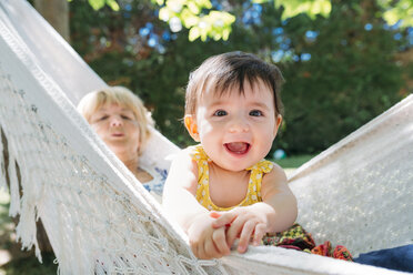 Spanien, Oma und Baby entspannen sich in einer Hängematte im Garten im Sommer - GEMF01828