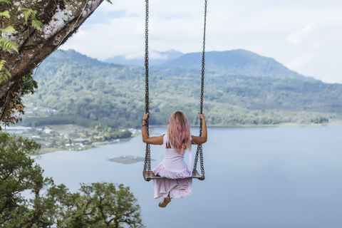 Indonesien, Bali, junge Frau auf Schaukel sitzend, lizenzfreies Stockfoto