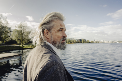 Porträt eines ernsten älteren Mannes an einem See, lizenzfreies Stockfoto