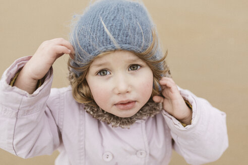 Portrait of unhappy little girl on the beach in winter - KMKF00100