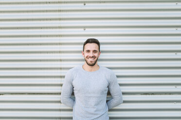 Portrait of laughing man with hands behind his back - RAEF01953