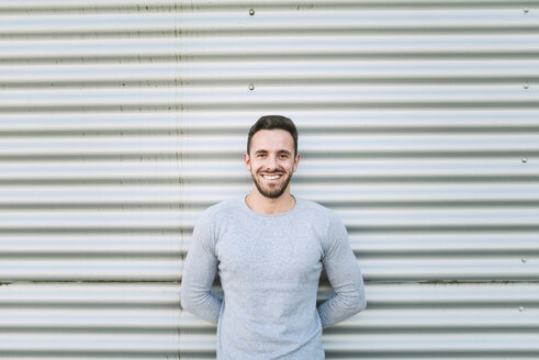 Portrait of laughing man with hands behind his back - RAEF01953