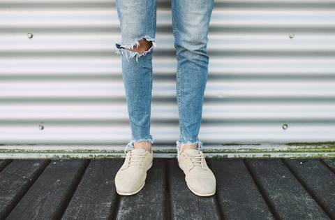 Beine eines Mannes in zerrissenen Jeans, lizenzfreies Stockfoto
