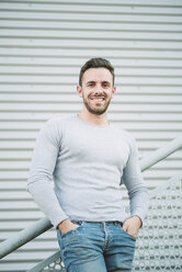 Portrait of smiling man with hands in his pockets - RAEF01959