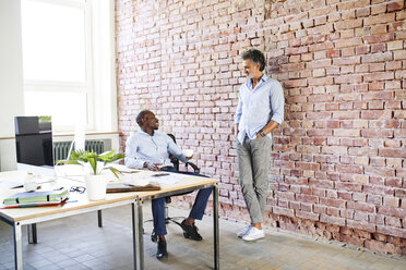 Two colleagues talking in loft office - HAPF02596