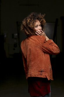 Porträt einer Frau mit Lederjacke vor einem dunklen Hintergrund - HHLMF00006