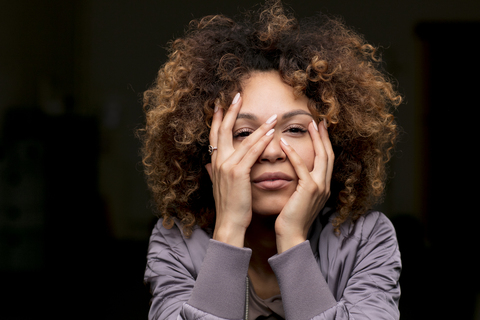 Porträt einer Frau mit Hand im Gesicht, lizenzfreies Stockfoto