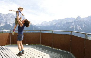 Austria, South Tyrol, mother lifting up her daughter - FKF02856