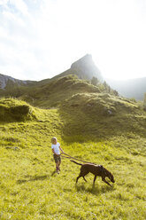 Österreich, Südtirol, junges Mädchen beim Wandern mit Hund - FKF02873