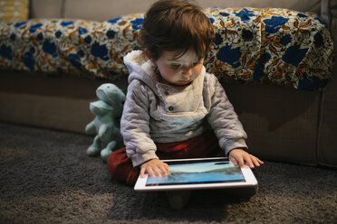 Kleines Mädchen schaut sich zu Hause Videos auf einem Tablet an - GEMF01838