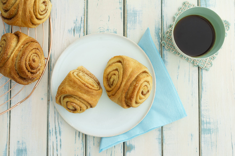 Selbstgebackene Franzbrötchen und eine Tasse Kaffee, lizenzfreies Stockfoto