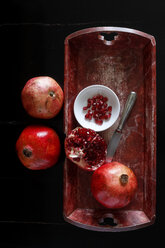 Whole pomegranate and pomegranate seed with bowl and knife on wooden tray - JTF00879