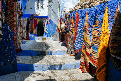 Marokko, Chefchaouen, Teppichgeschäft präsentiert Angebote im Freien - KIJF01811