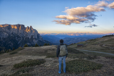 Italien, Südtirol, Seiser Alm, Wanderer vor dem Schlern bei Sonnenaufgang - LOMF00677