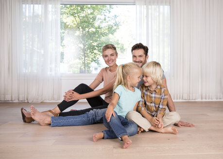 Relaxed family sitting on the floor at home - MFRF01125