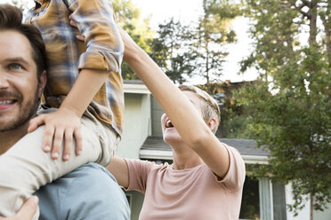 Happy parents with son in front of their home - MFRF01138