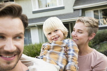 Portrait of happy parents with son in front of their home - MFRF01139
