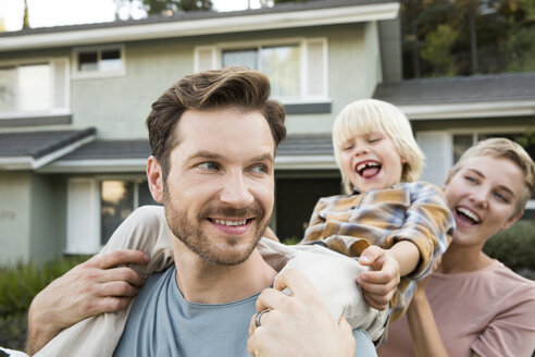 Happy parents with son in front of their home - MFRF01140