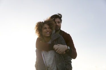 Young man embracing smiling girlfriend outdoors - HHLMF00074