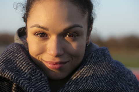 Porträt einer lächelnden jungen Frau im Freien, lizenzfreies Stockfoto