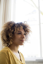 Portrait of smiling young woman at the window - HHLMF00116