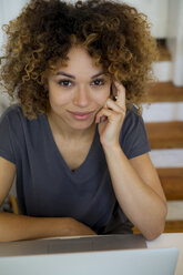 Portrait of smiling young woman with laptop - HHLMF00124