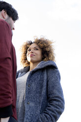 Low-angle view of young couple standing outdoors - HHLMF00135