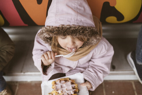 Belgien, kleines Mädchen isst belgische Waffel im Winter im Freien - KMKF00107