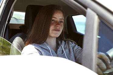 Portrait of young woman with freckles driving car - SRYF00698