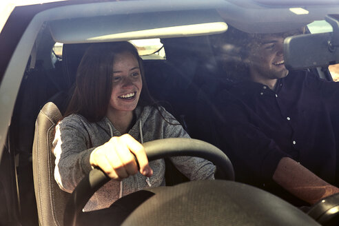 Happy young woman with boyfriend driving car - SRYF00700