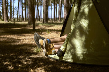 Schuhe ragen aus einem Zelt im Wald heraus - SRYF00718