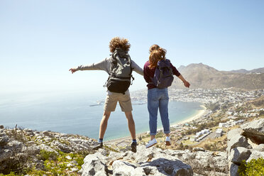 South Africa, Cape Town, young couple jumping on a trip at the coast - SRYF00733