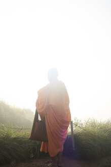 Thailand, Phu Chi Fa, betender buddhistischer Mönch mit orangefarbenem Gewand - IGGF00337