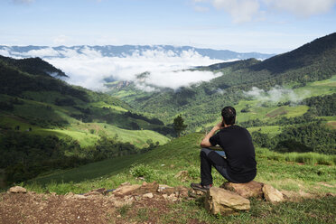 Thailand, Phu Chi Fa, Reisender auf dem Gipfel eines Hügels mit Blick über Reisfelder - IGGF00340