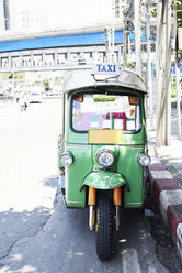 Thailand, Bangkok, grünes Tuk-Tuk-Fahrzeug auf der Straße geparkt - IGGF00342