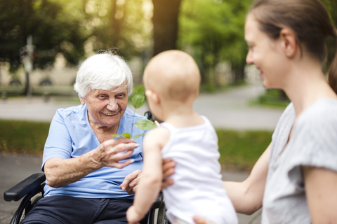 Portrait of happy senior woman with daughter and granddaughter in a park stock photo